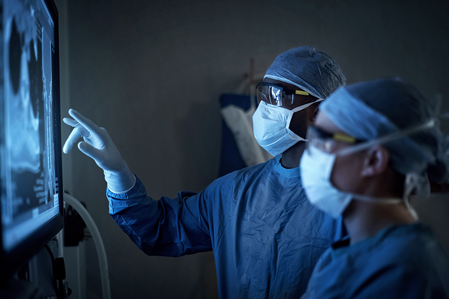 A group of specialists reviews a patient x-ray, looking for signs of severe bone infection